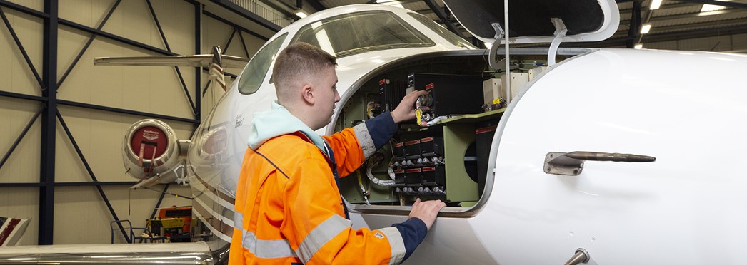 Student Working On Side Panel Of Plane Landscape
